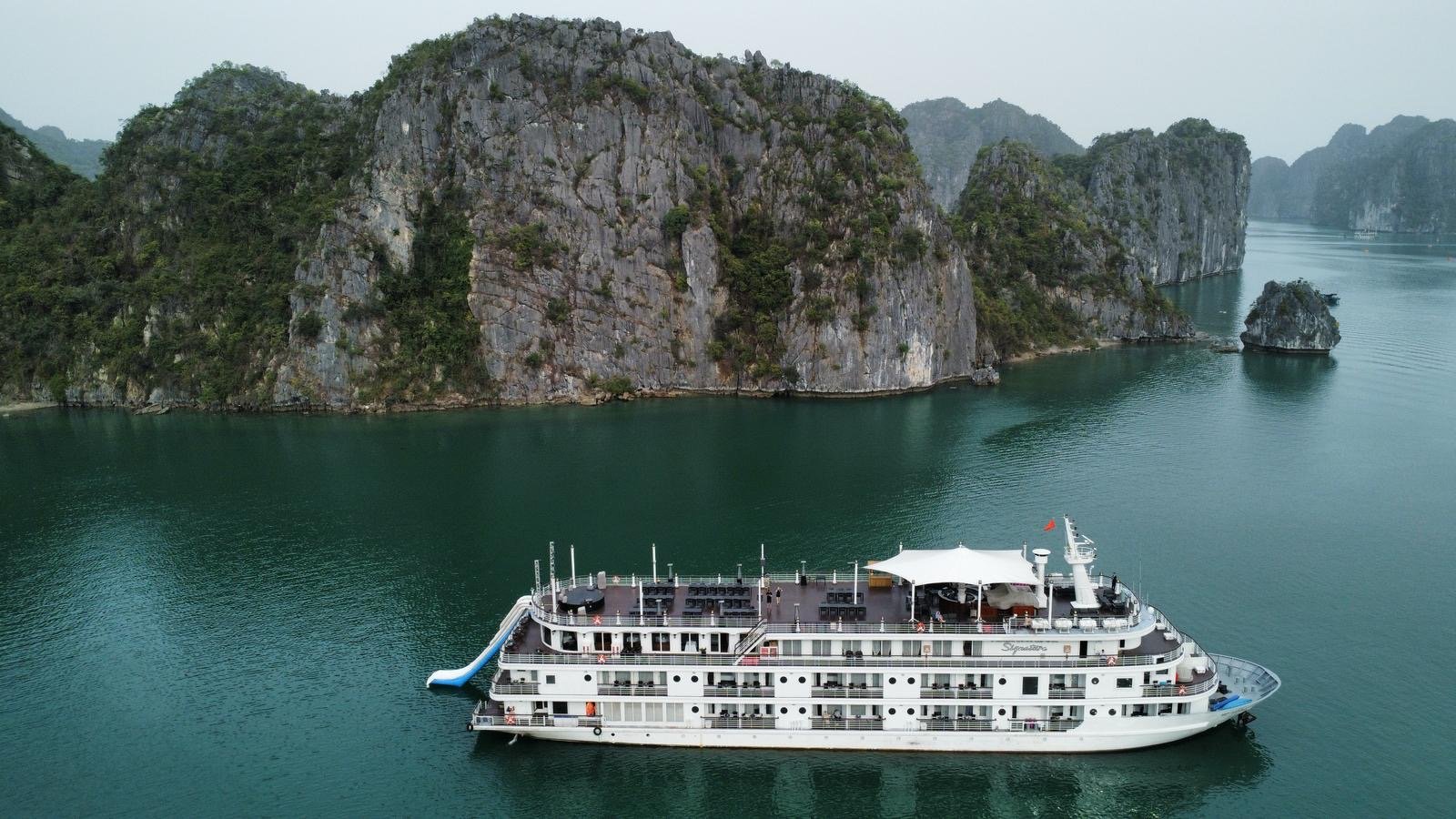 Vista aérea de un crucero boutique navegando entre los peñascos de Halong Bay, Vietnam