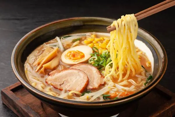 Tazón de ramen con fideos y caldo aromático.